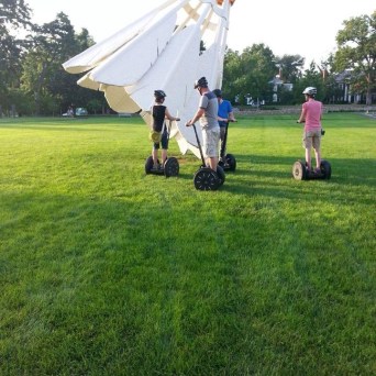 family of four riding their segway on the park