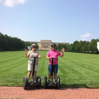 couple waving their hand on their segway